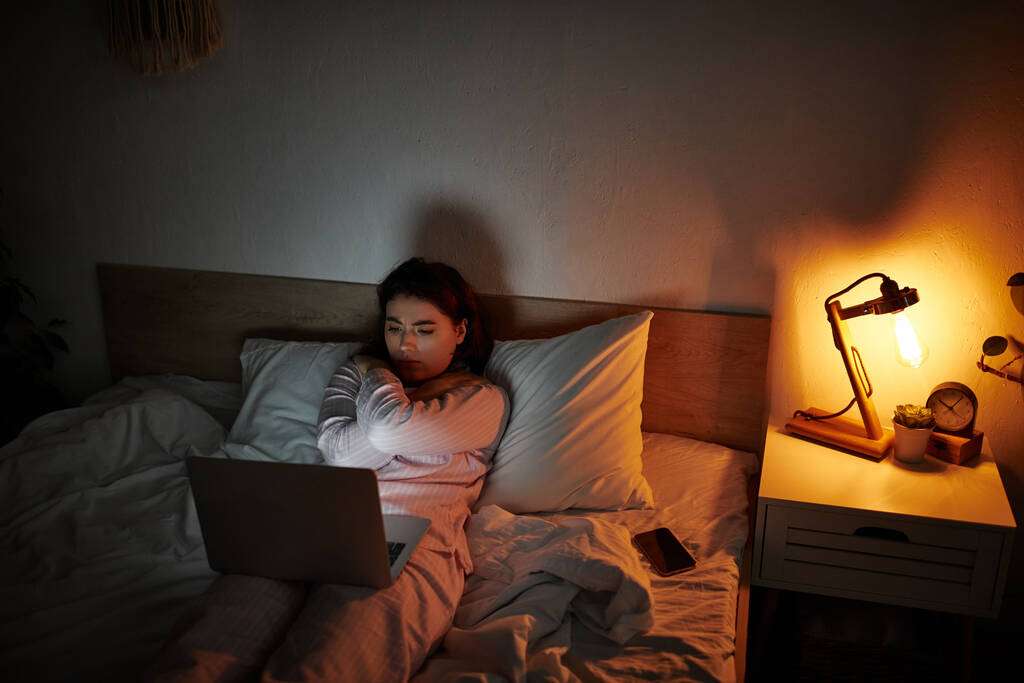 Perché mi sento vuota dopo il sesso? Donna in luce calda seduta sul letto in momento di introspezione, simbolo del senso di vuoto dopo il sesso e della riflessione emotiva femminile.
